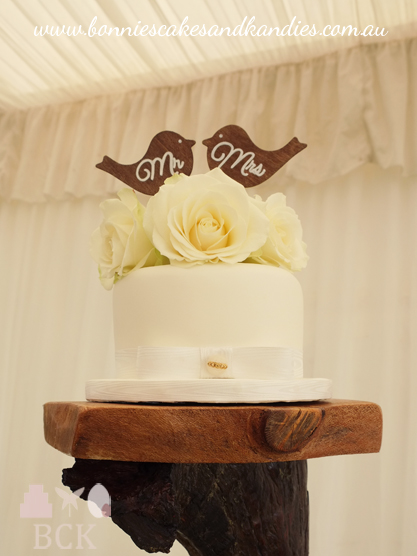 Dark chocolate mud cutting cake with white chocolate fondant, beautiful fresh roses and wooden lovebird cake topers  |  Bonnie's Cakes & Kandies, Gympie.