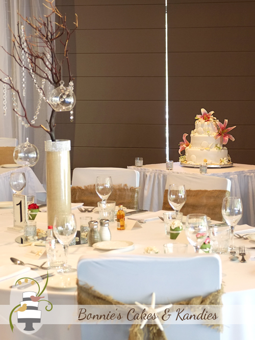 Three tier Rainbow Beach wedding cake with sand, seashells and fresh flowers | Bonnie's Cakes & Kandies